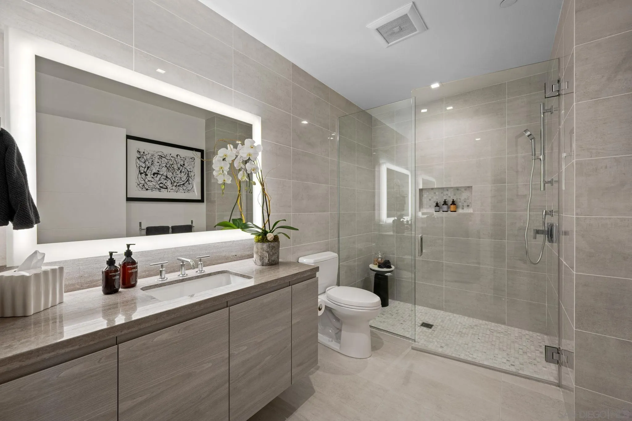 2604 Fifth Avenue, Unit 804 San Diego, CA 92103 - Photo 47 of 72 a bathroom with a granite countertop sink a toilet a mirror and shower