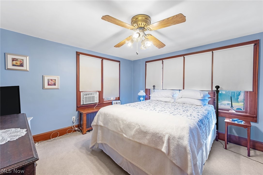 221 Raff Road Northwest Canton, OH 44708 - Photo 21 of 31 Ceiling fan with light kit, multiple windows with blinds, wood-finish window trim, wall-mounted air conditioning unit, and carpeting