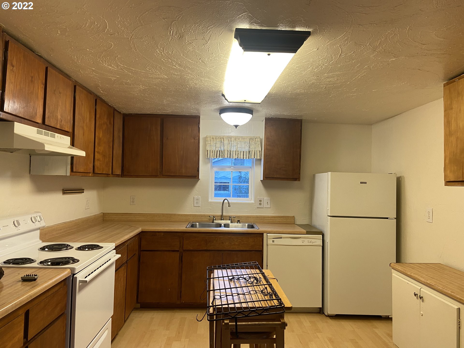 902 25th Place Springfield, OR 97477 - Photo 3 of 15 a kitchen with a refrigerator a stove a sink cabinets and a counter top space