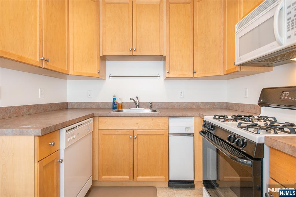 201 Dey Street, Unit 124 Harrison, NJ 07029 - Photo 13 of 26 a kitchen with stainless steel appliances granite countertop a sink stove and cabinets