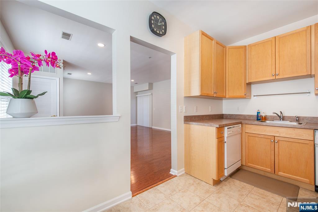 201 Dey Street, Unit 124 Harrison, NJ 07029 - Photo 14 of 26 a kitchen with granite countertop a sink cabinets and wooden floor