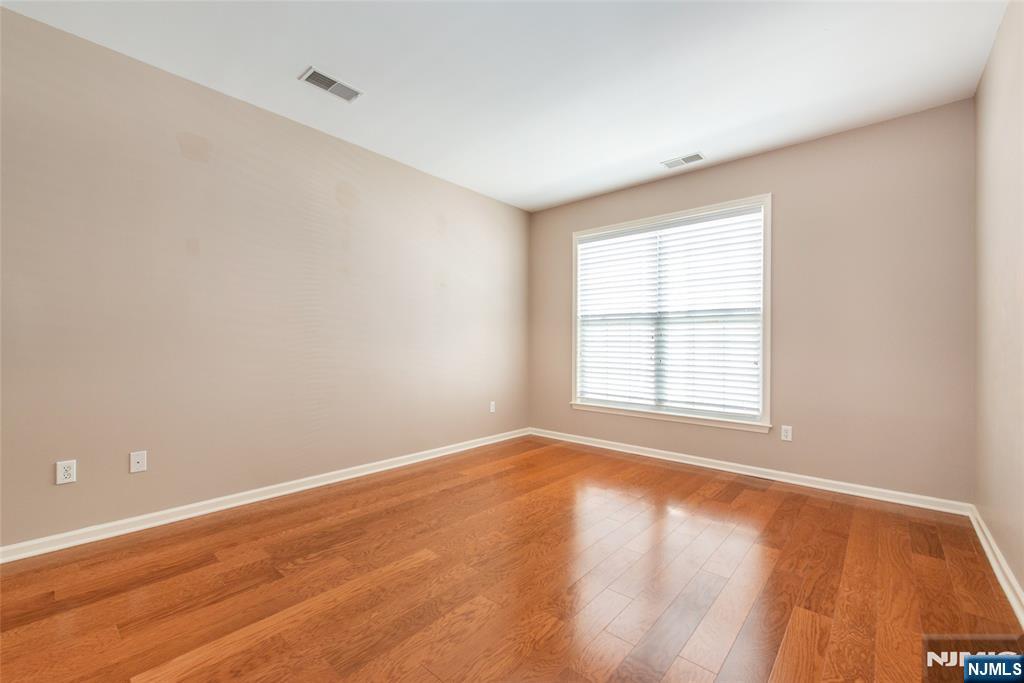 201 Dey Street, Unit 124 Harrison, NJ 07029 - Photo 17 of 26 an empty room with wooden floor and windows