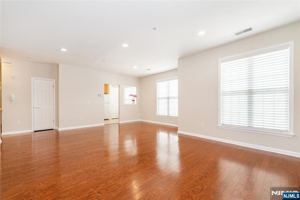 201 Dey Street, Unit 124 Harrison, NJ 07029 - Photo 6 of 26 a view of an empty room with wooden floor and a window