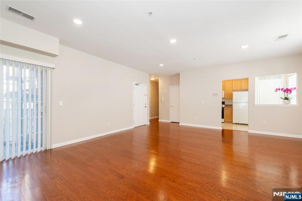 201 Dey Street, Unit 124 Harrison, NJ 07029 - Photo 7 of 26 an empty room with wooden floor and windows