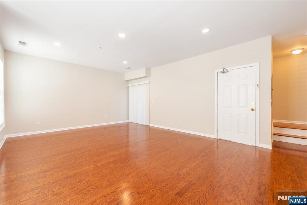 201 Dey Street, Unit 124 Harrison, NJ 07029 - Photo 8 of 26 wooden floor in an empty room with a window
