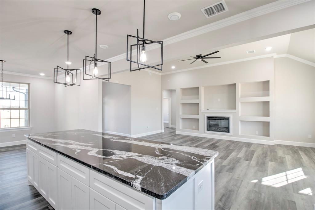 6180 Old Sherman Road Whitesboro, TX 76273 - Photo 10 of 30 a kitchen with stainless steel appliances granite countertop a sink a stove and a wooden floor
