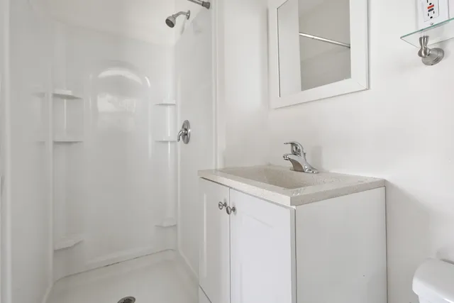 a bathroom with a sink a toilet and shower