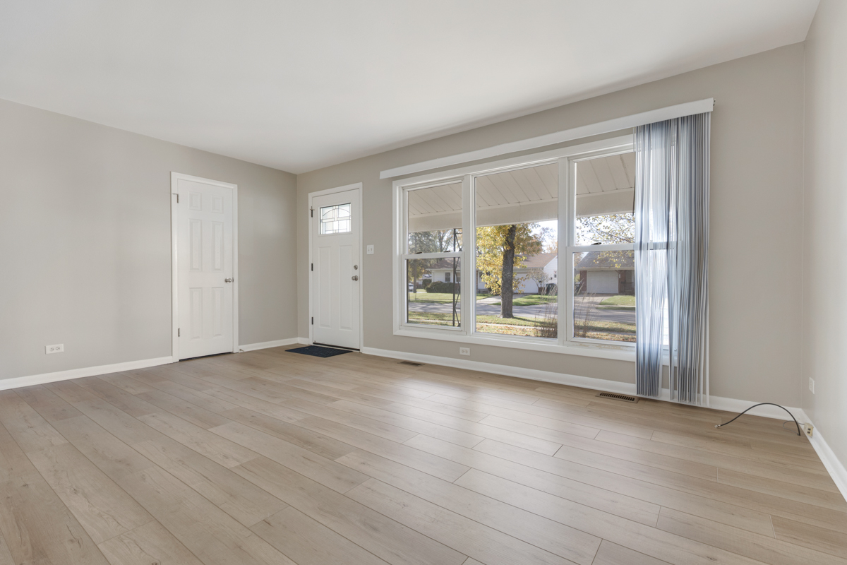 635 Love Street Elk Grove Village, IL 60007 - Photo 2 of 20 a view of an empty room with wooden floor and a window