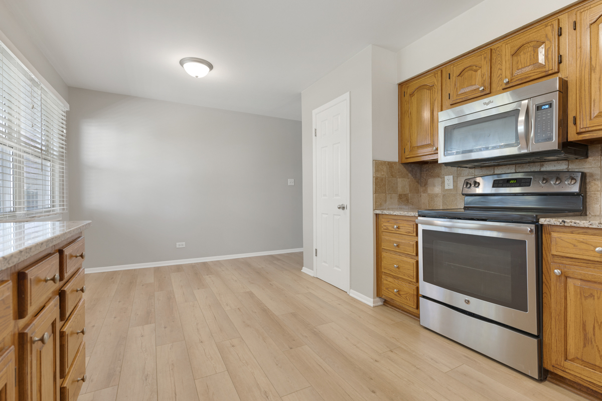 635 Love Street Elk Grove Village, IL 60007 - Photo 5 of 20 a kitchen with stainless steel appliances a stove microwave and sink
