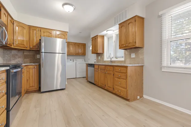 a kitchen with stainless steel appliances granite countertop a refrigerator sink and cabinets