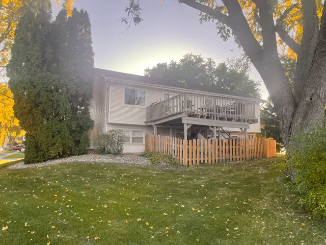 a view of a house with a big yard and large tree