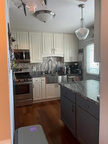 a kitchen with stainless steel appliances granite countertop a stove a sink and a refrigerator