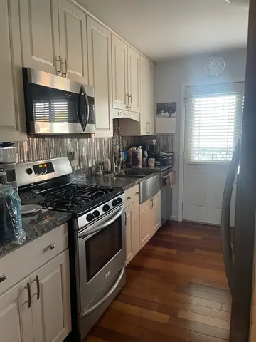 a kitchen with granite countertop a stove and a sink