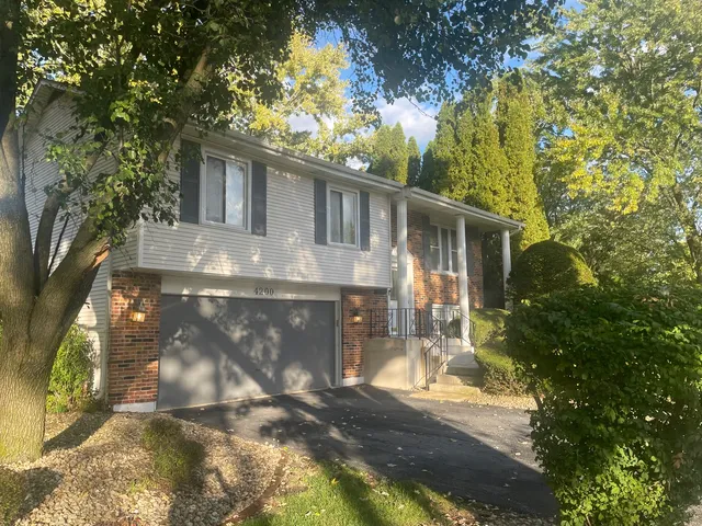 a front view of a house with yard and green space
