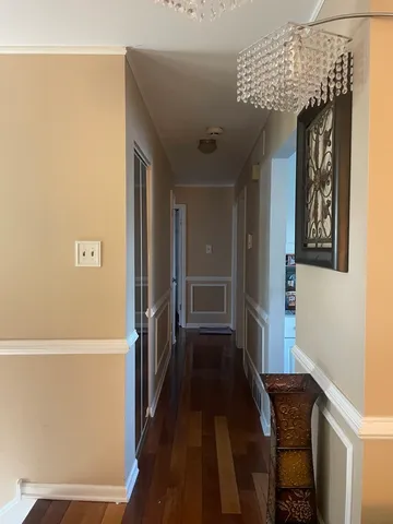 a view of a hallway with wooden floor and staircase