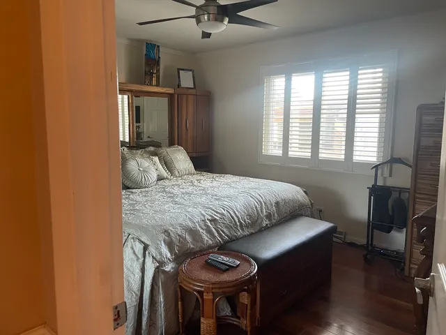 a bedroom with a bed and a chair with the bookshelf