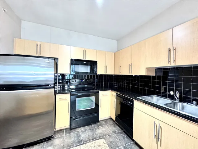 a kitchen with granite countertop a sink and a stove