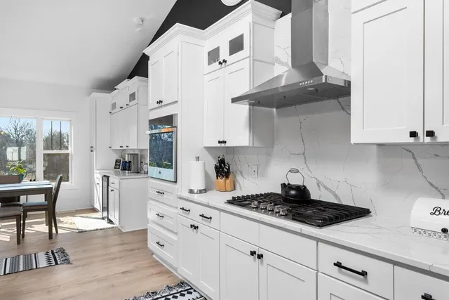 a kitchen with white cabinets and appliances