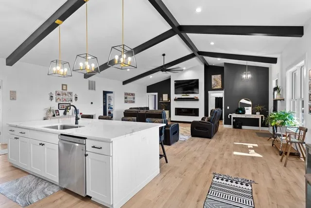 a view of living room with kitchen island stainless steel appliances furniture a dining table and chairs