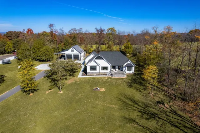 a view of a patio with table and chairs potted plants and a large tree