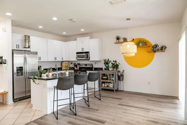 a kitchen with a refrigerator and a stove top oven