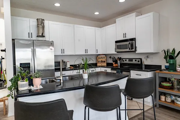a kitchen with kitchen island granite countertop a sink stove and refrigerator