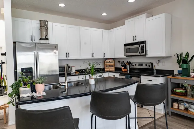 a kitchen with kitchen island granite countertop a sink stove and refrigerator