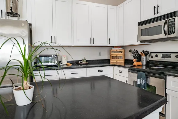 a kitchen with stainless steel appliances granite countertop a sink a stove and cabinets