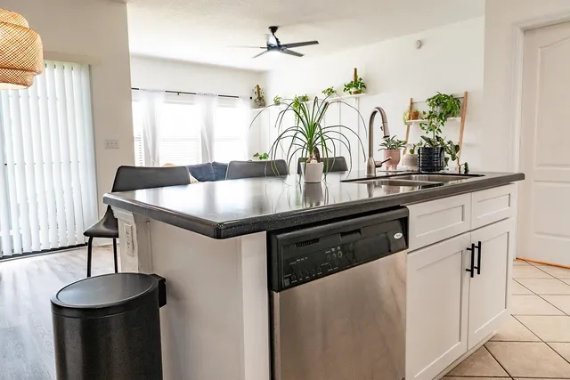 a kitchen with kitchen island granite countertop a sink and a refrigerator