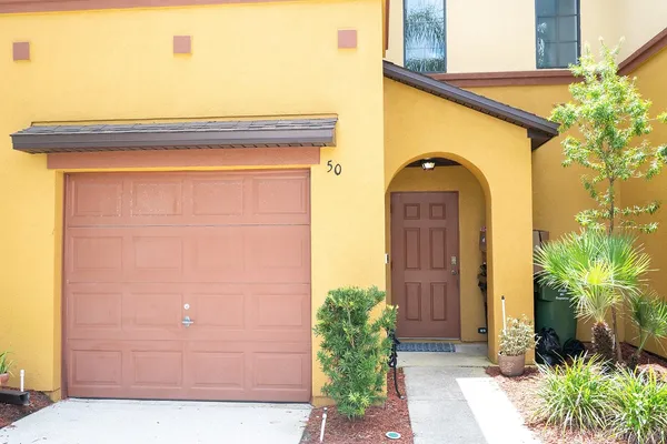 a front view of a house with plants
