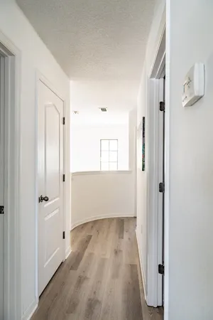 a view of a hallway with wooden floor and closet area