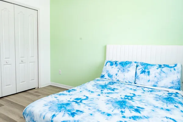 a bedroom with a bed and a painting on the wall