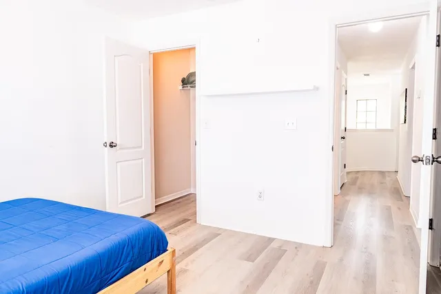 a bedroom with a bed and a refrigerator