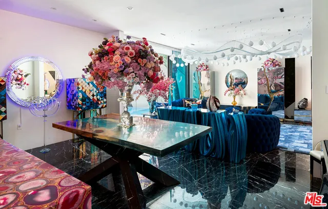 a living room with lots of furniture and paintings on the wall