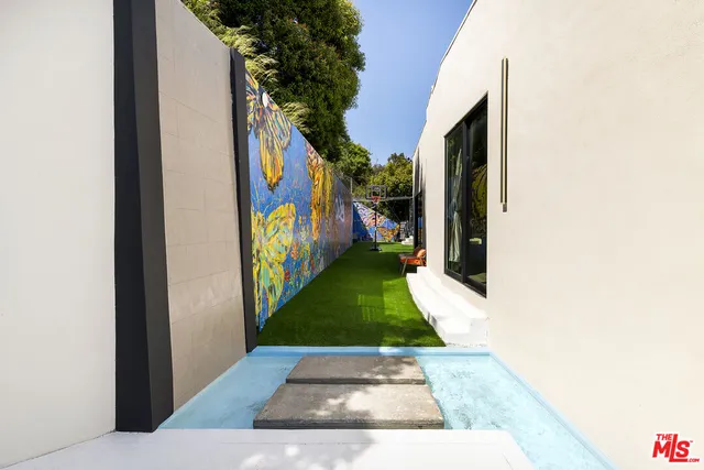 a view of a backyard with plants and table