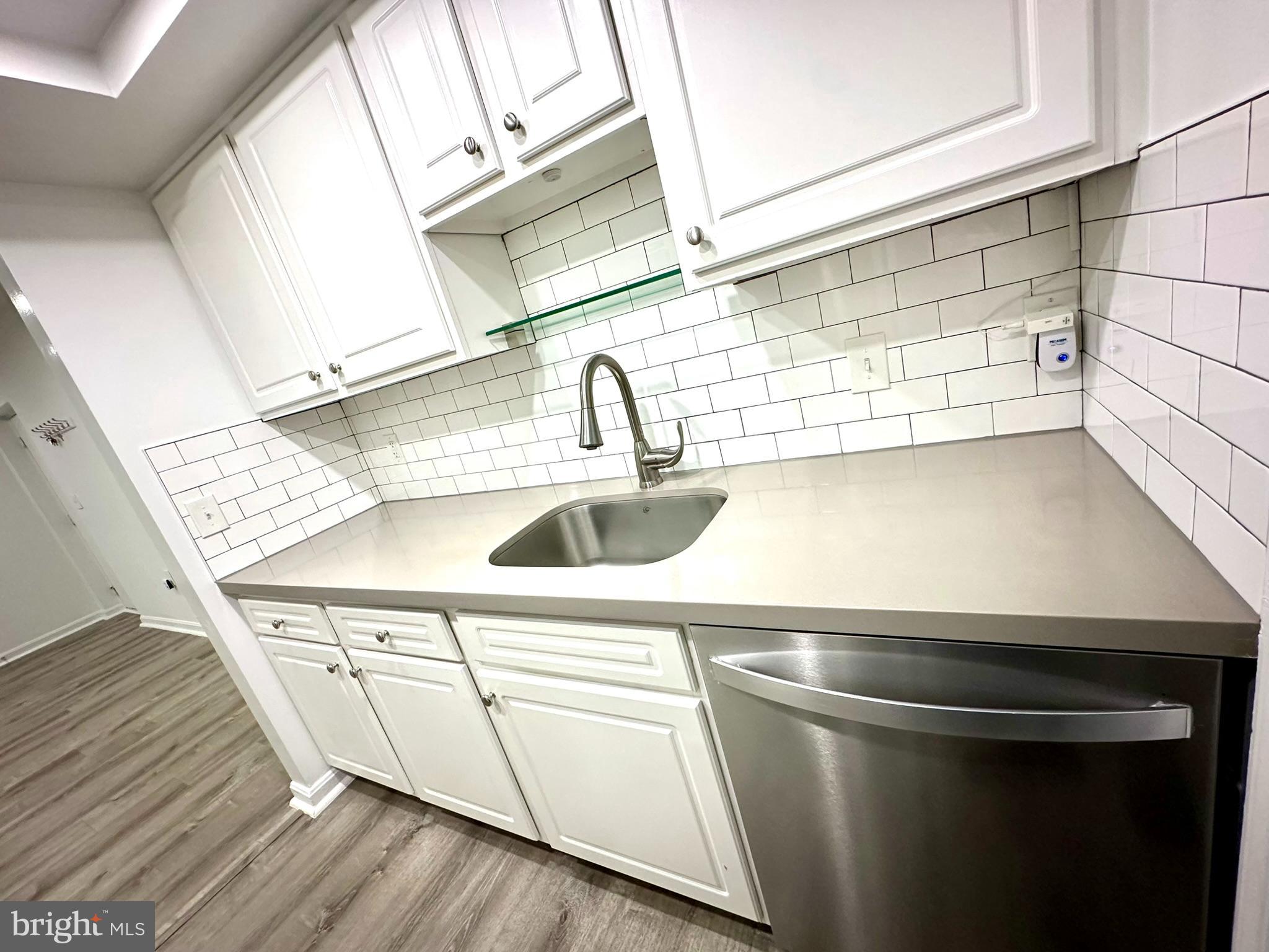 18334 Streamside Drive, Unit 202 Gaithersburg, MD 20879 - Photo 22 of 61 a close view of sink and washing machine with wooden floor