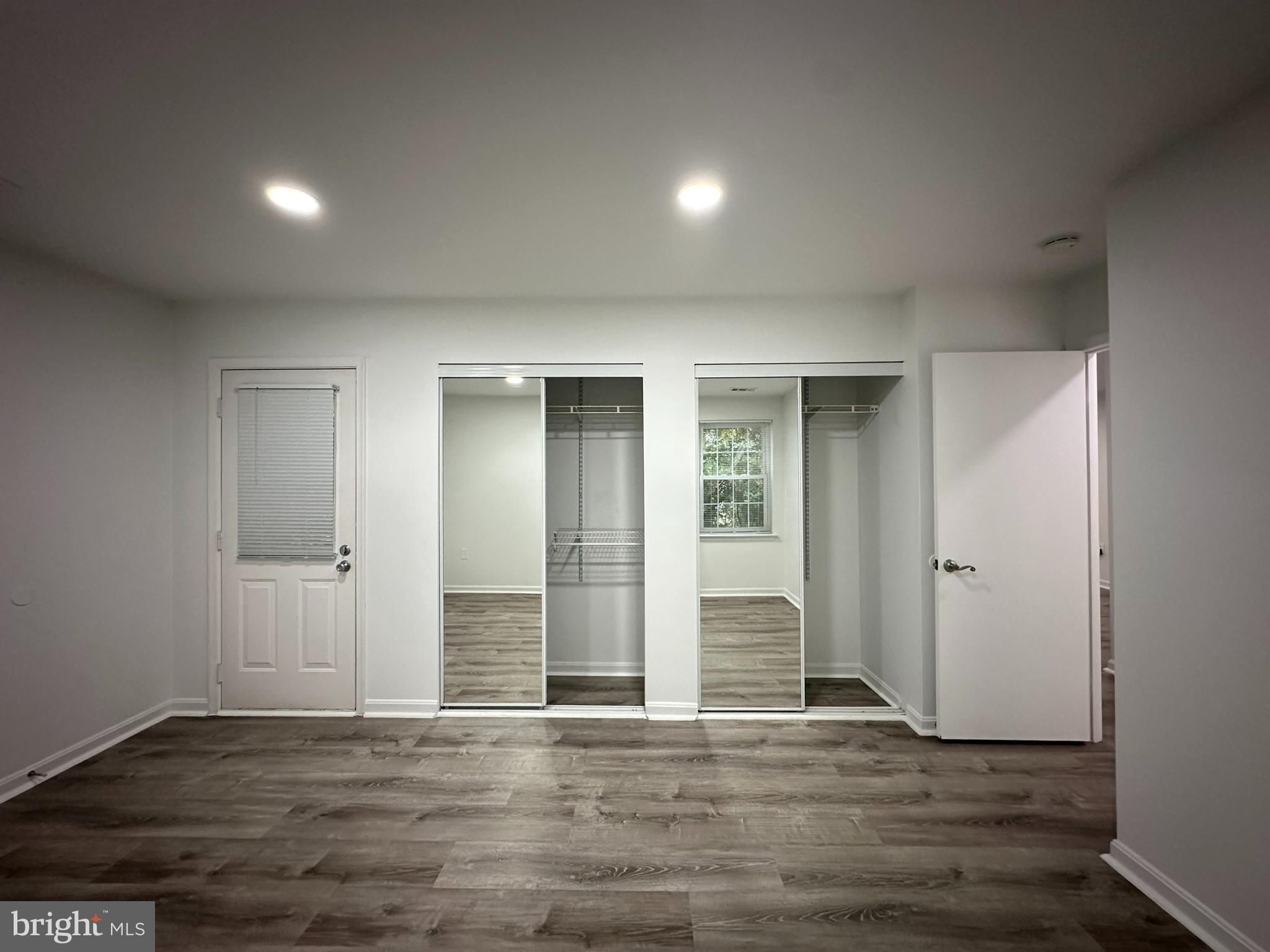 18334 Streamside Drive, Unit 202 Gaithersburg, MD 20879 - Photo 34 of 61 an empty room with wooden floor and door