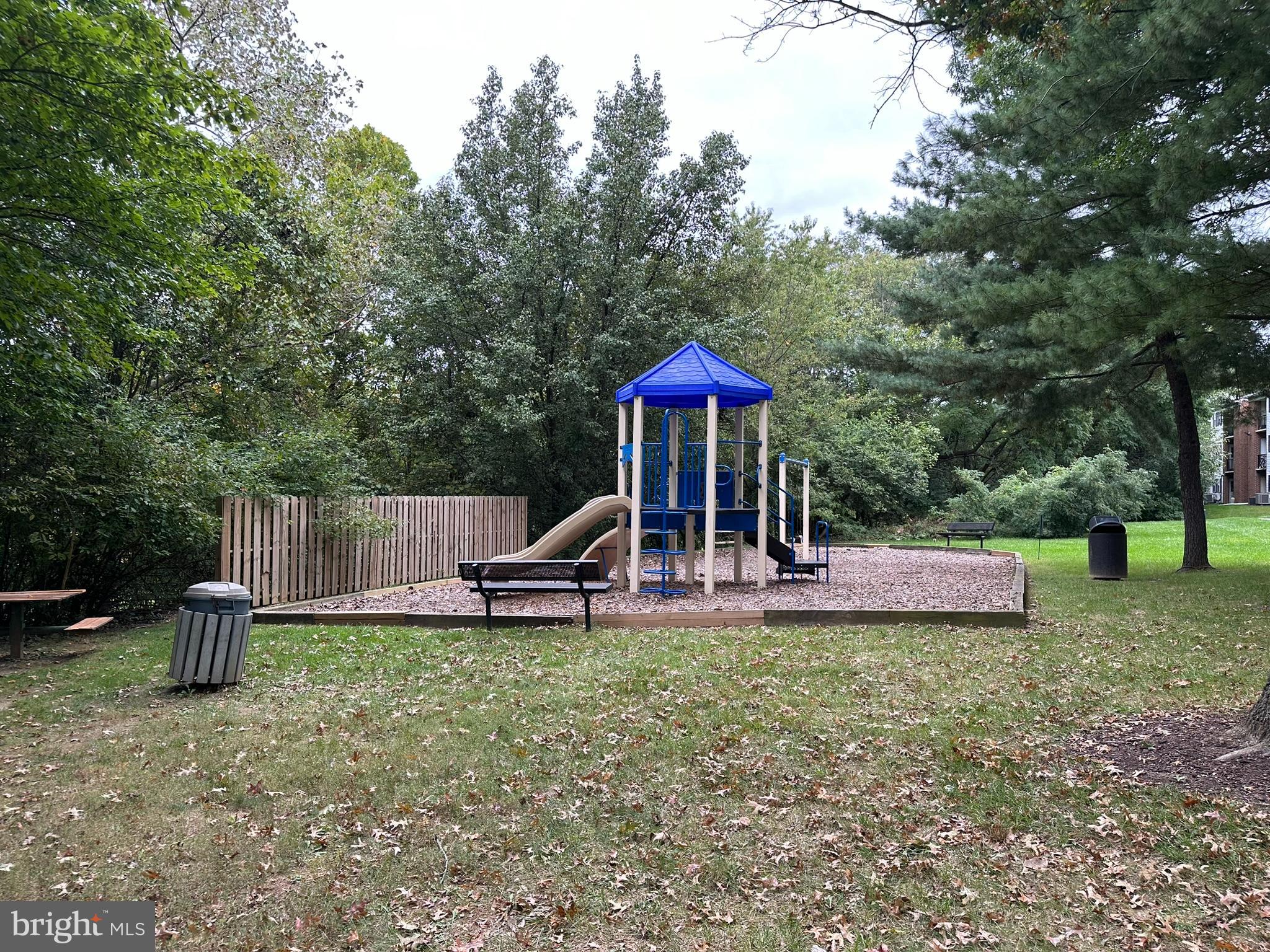 18334 Streamside Drive, Unit 202 Gaithersburg, MD 20879 - Photo 46 of 61 a view of a table and chairs under an umbrella