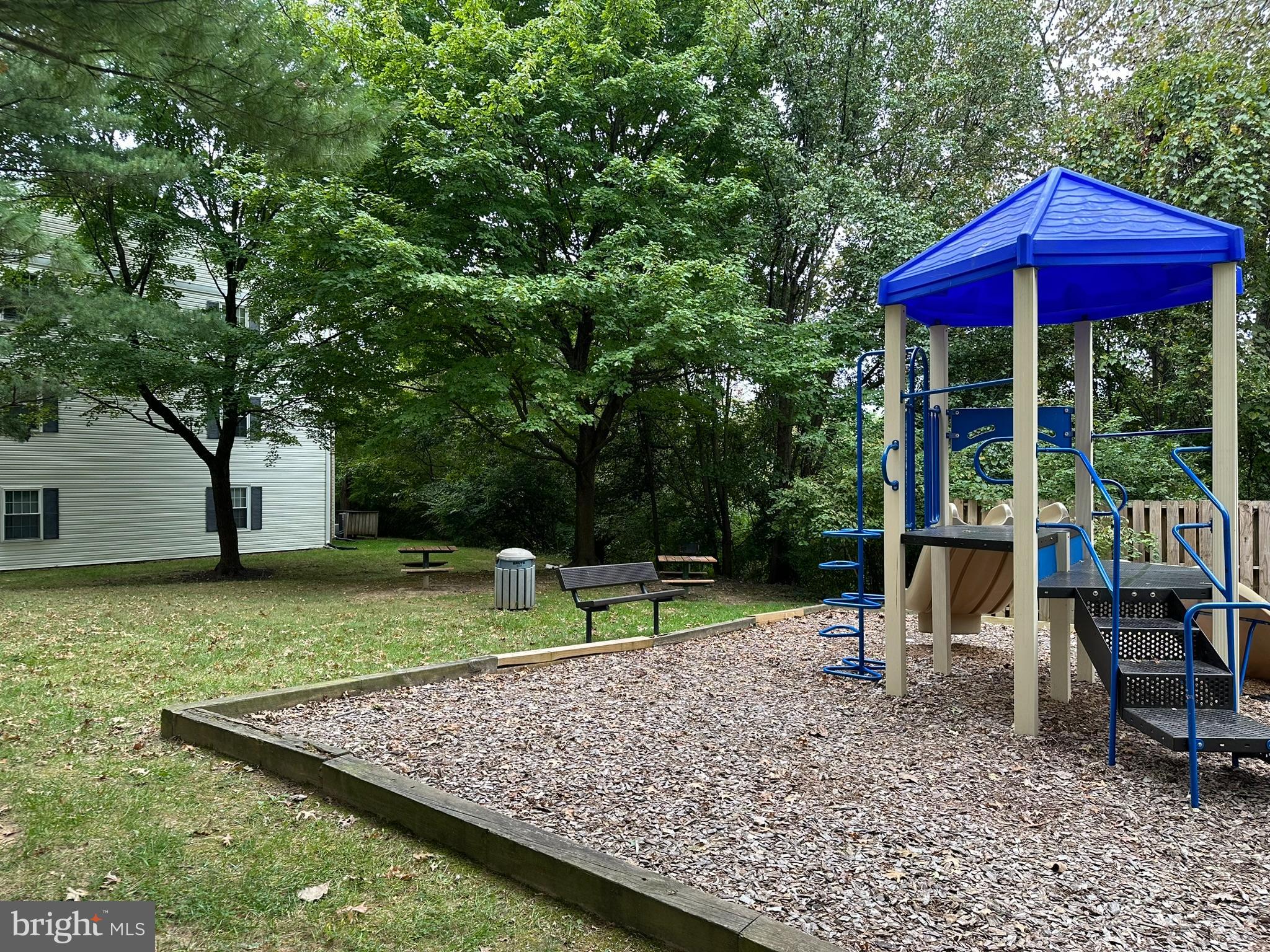 18334 Streamside Drive, Unit 202 Gaithersburg, MD 20879 - Photo 47 of 61 a view of a wooden deck with chairs and a yard