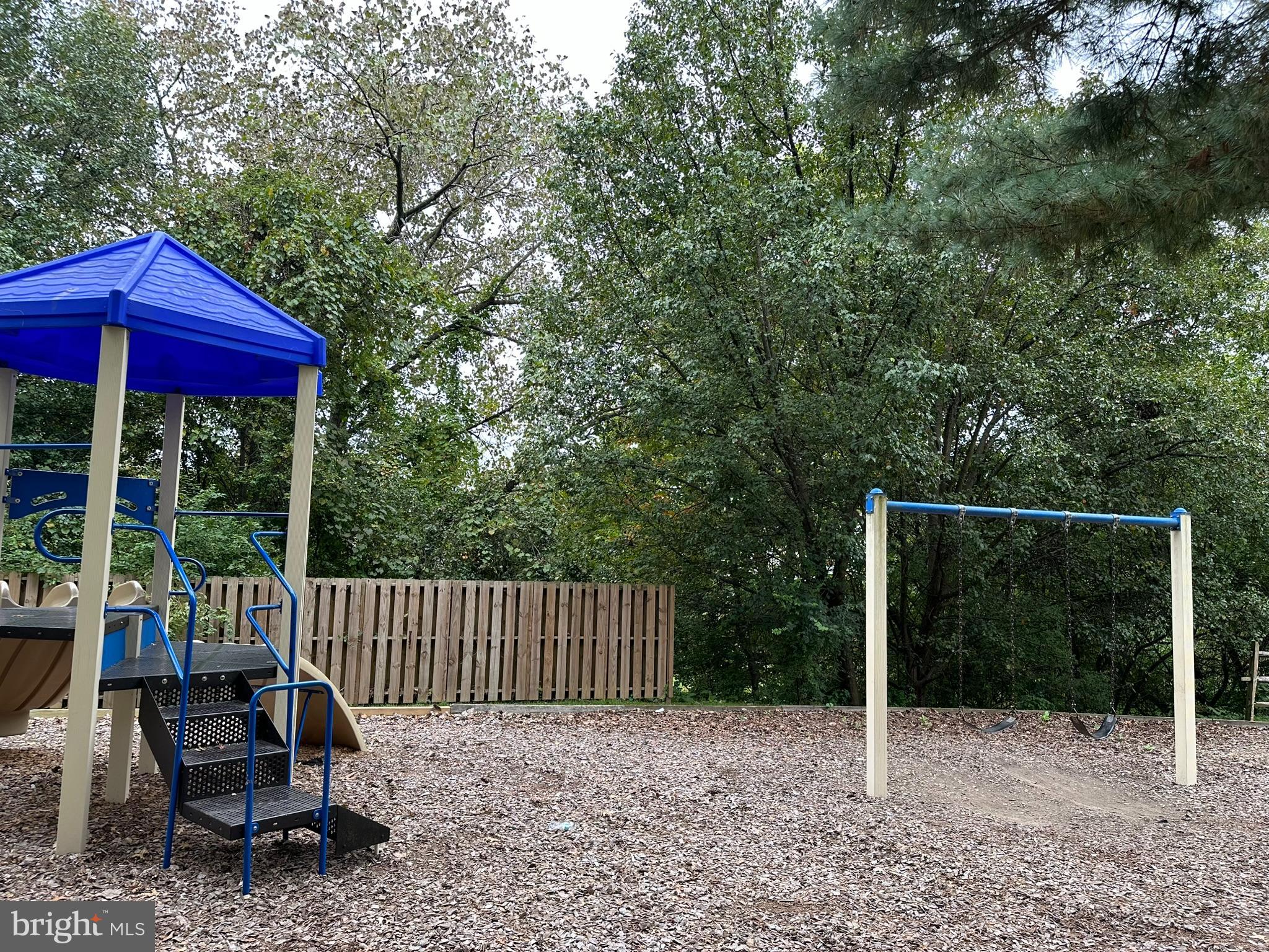 18334 Streamside Drive, Unit 202 Gaithersburg, MD 20879 - Photo 48 of 61 a wooden bench sitting in front of a house