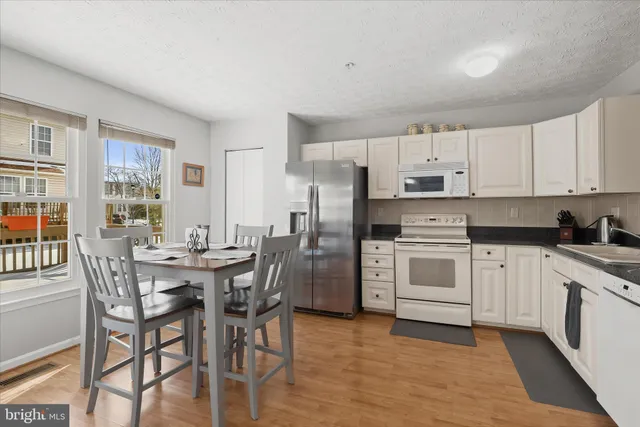 a kitchen with white cabinets and white appliances