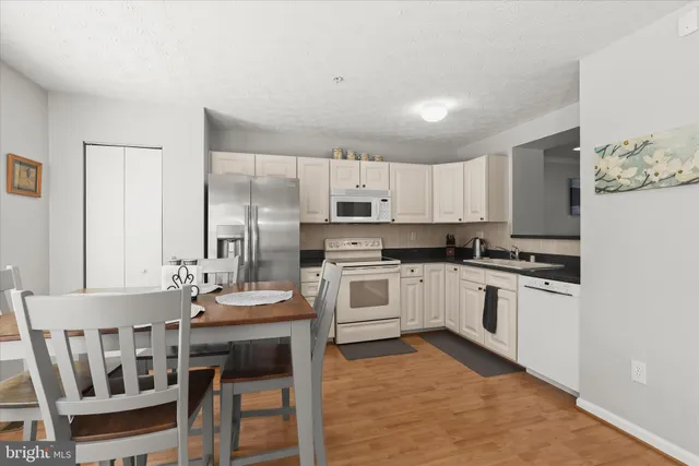 a kitchen with a table chairs microwave and cabinets