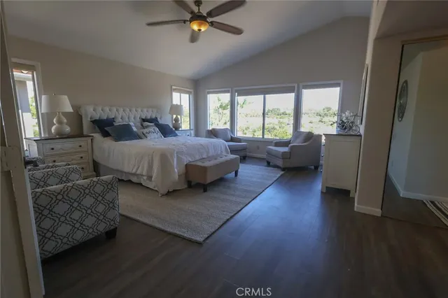 a spacious bedroom with a bed and wooden floor