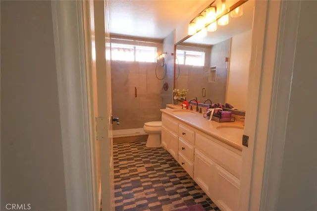 a bathroom with a double vanity sink toilet and a mirror