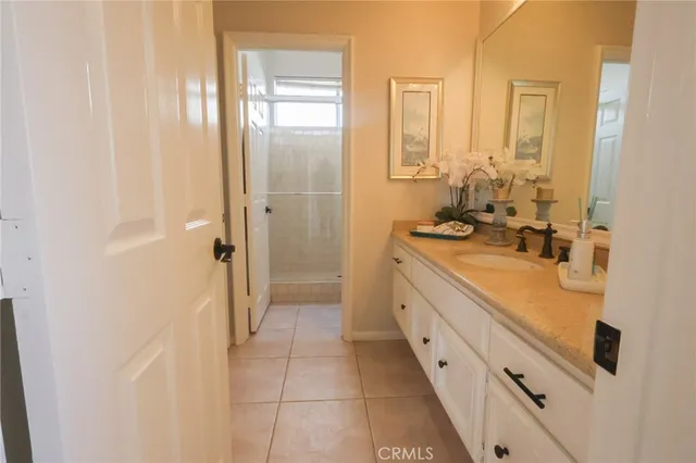 a spacious bathroom with a double vanity sink a mirror and a shower