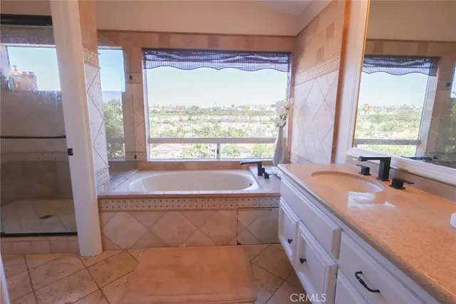 a spacious bathroom with a tub sink and mirror