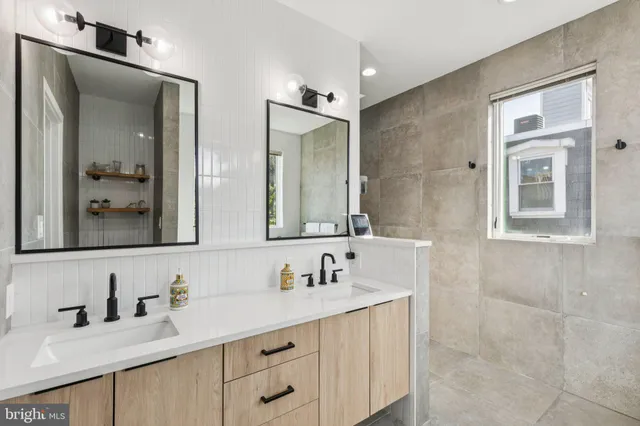 a bathroom with double vanity sinks a vanity and a mirror