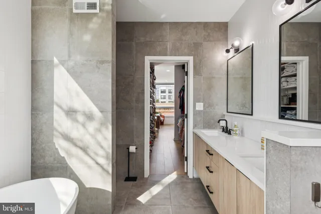 a spacious bathroom with a double vanity sink toilet and shower