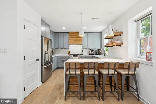 a kitchen with a table chairs refrigerator and window
