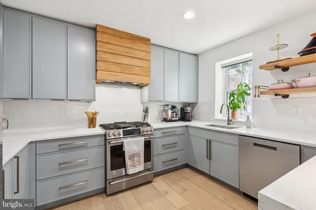 a kitchen with a white cabinets and wooden floor